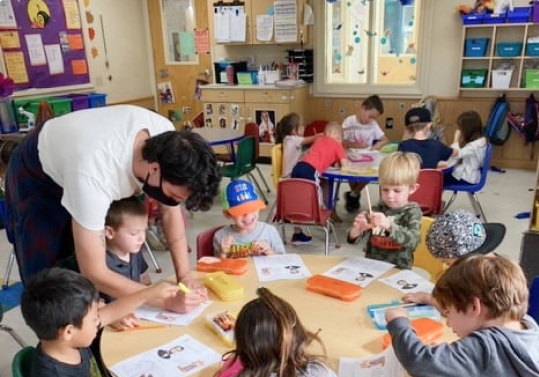 Teacher doing art with students.