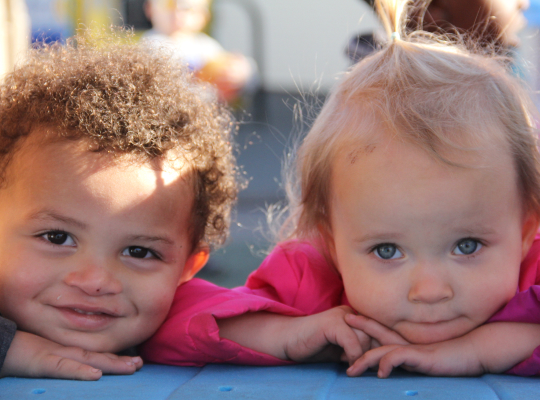 Two little kids looking directly at the camera.